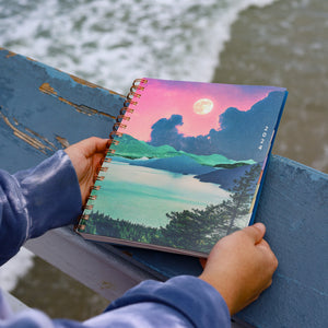 WAAV 2024 Planner named megan featured a relaxing lake front view with mountainous background, starlight skies, moon, and nature in a 7x9 planner size.
