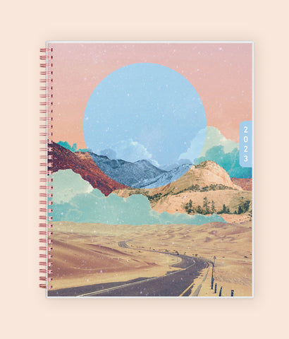 Enjoy the WAAV experience with this 2023 8.5x11 weekly monthly planner featuring a beautiful artistic cover highlighting moutnains, sandy hills, stretch of road, and moon.