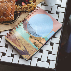 Enjoy the WAAV experience with this 2023 5x8 weekly monthly planner featuring a beautiful artistic cover highlighting mountains, sandy hills, stretch of road, and moon. 
