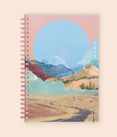 Enjoy the WAAV experience with this 2023 5x8 weekly monthly planner featuring a beautiful artistic cover highlighting mountains, sandy hills, stretch of road, and moon.