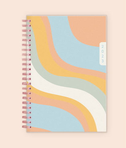 Enjoy this 2023 WAAV planner in 5x8 featuring a wavy cover in blue, orange, white, and green.