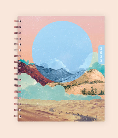 Enjoy the WAAV experience with this 2023 7x9 weekly monthly planner featuring a beautiful artistic cover highlighting moutnains, sandy hills, stretch of road, and moon.
